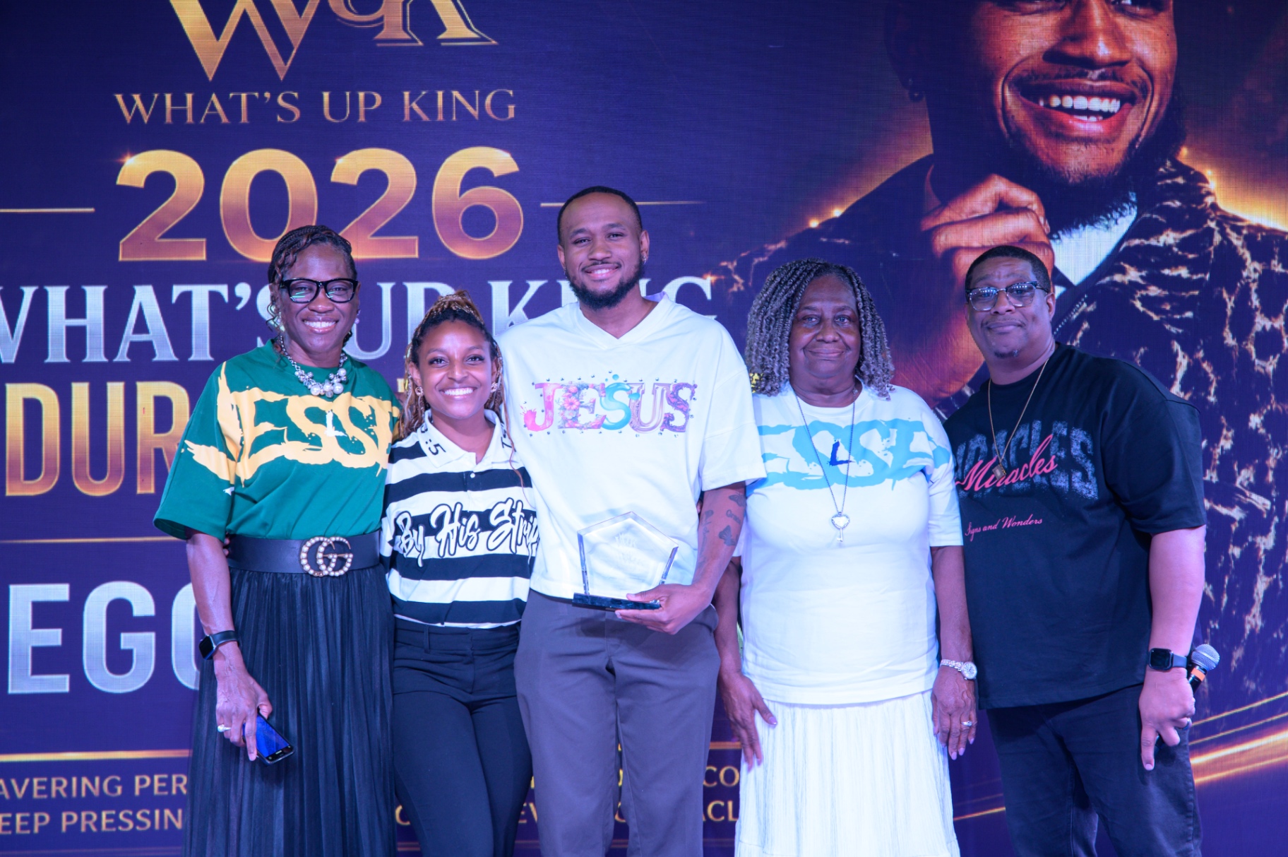 Five summit participants smiling together while presenting an award